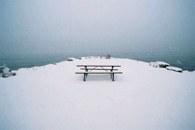 Snow-covered picnic table by the sea