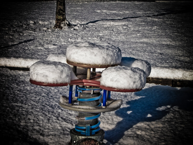 Snow-covered playground seesaw