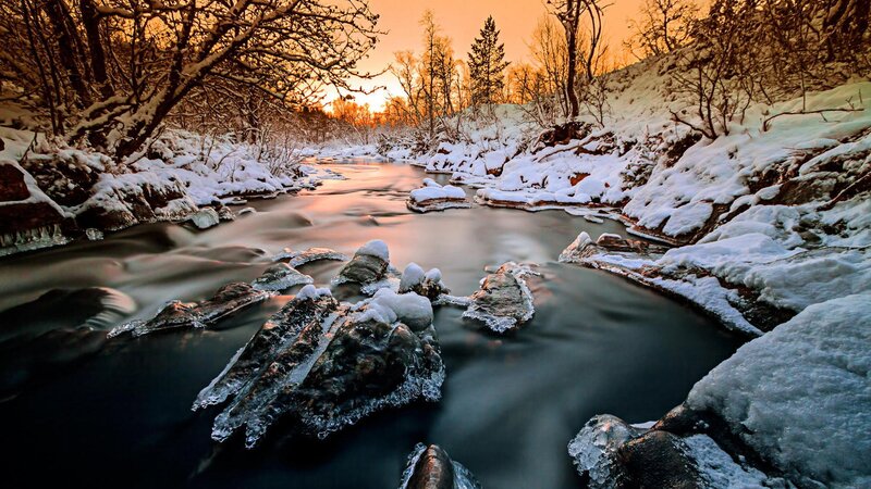 Snow-covered River at Sunset — Orange, Serene, Photograph, Trees, Rocks