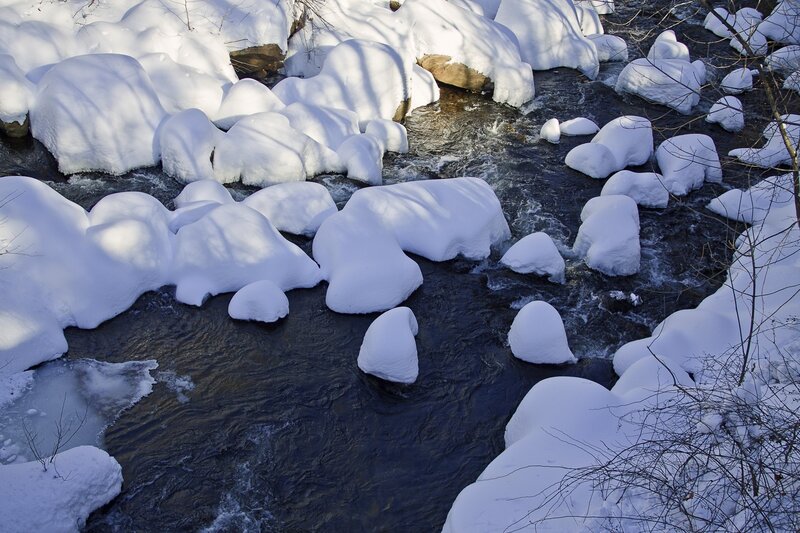 Snow-covered river rocks