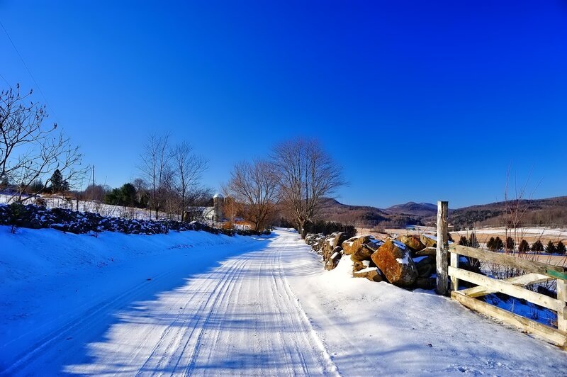 Snow-covered Road — Blue, Serene, Winter, Photograph, Trees, Fence, Mountains