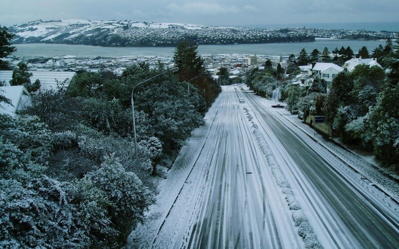 Snow-covered road in coastal town
