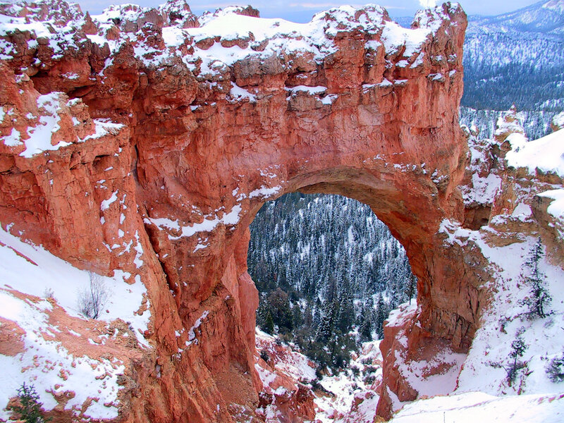 Snow-covered rock arch in canyon