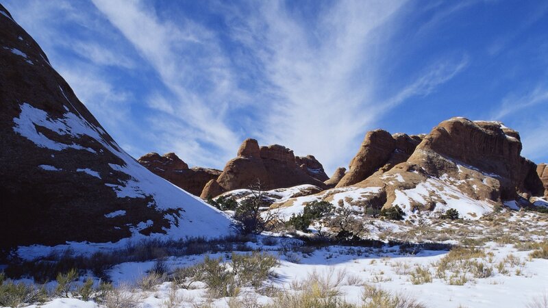 Snow-covered rock formations under blue sky