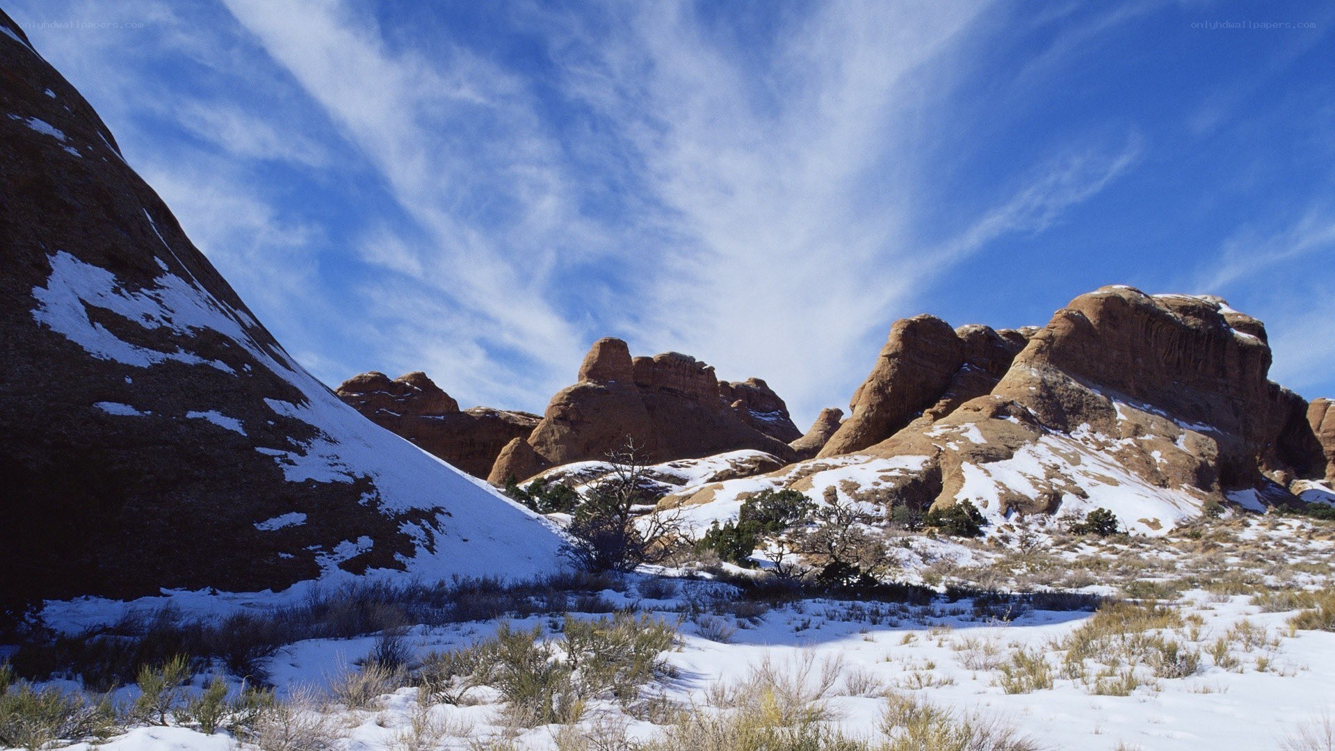 Snow-covered rock formations under blue sky