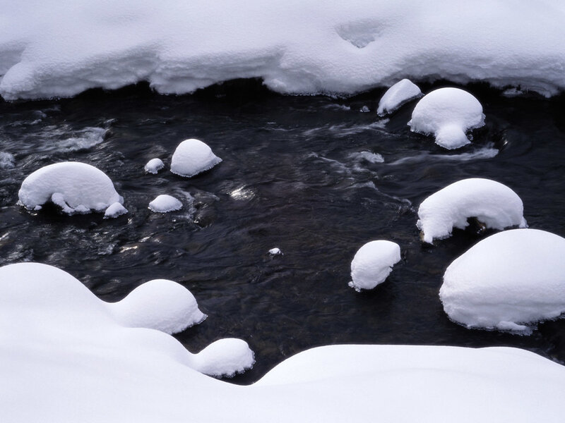 Snow-covered rocks in a stream