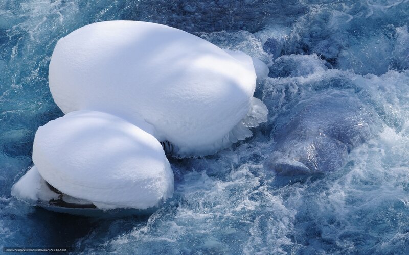 Snow-covered rocks in rushing water