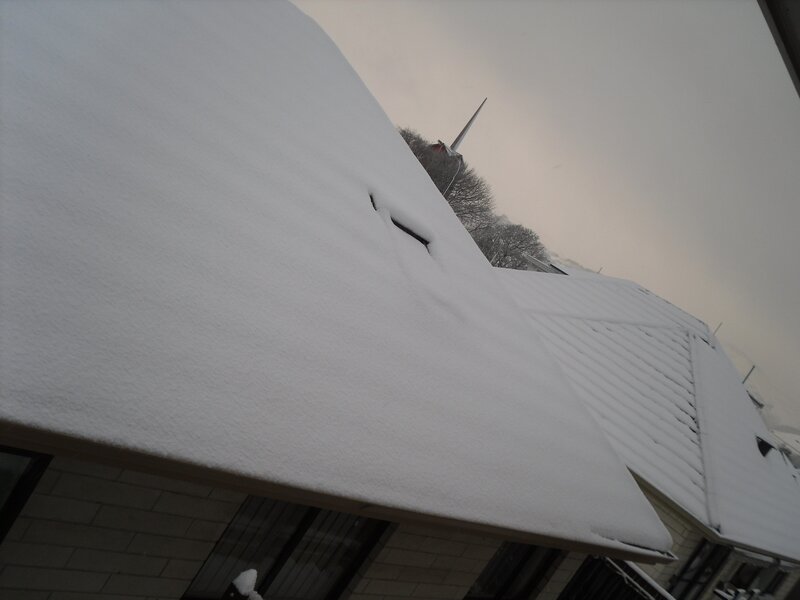Snow-covered roof with church steeple