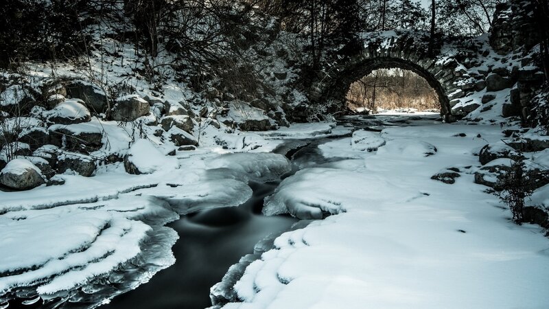 Snow-covered Stream under Bridge