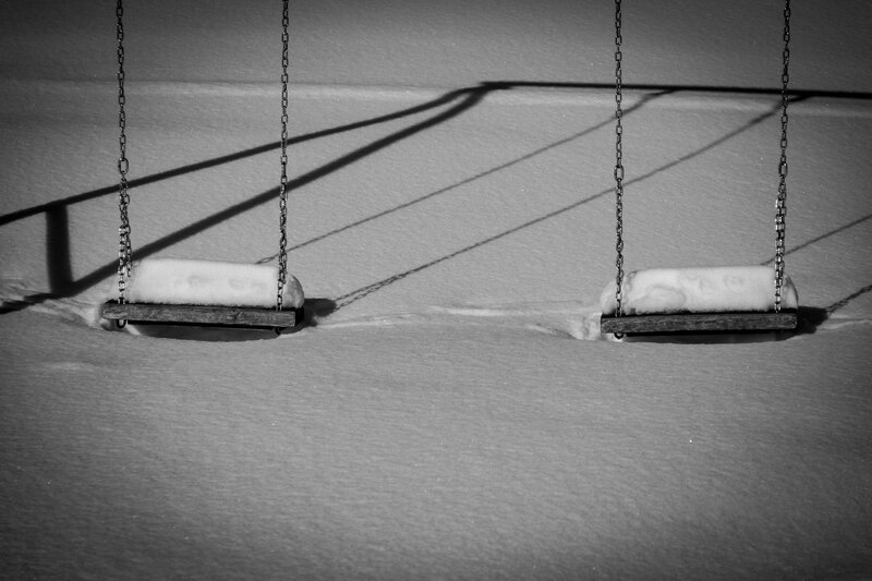 Snow-covered swings in winter