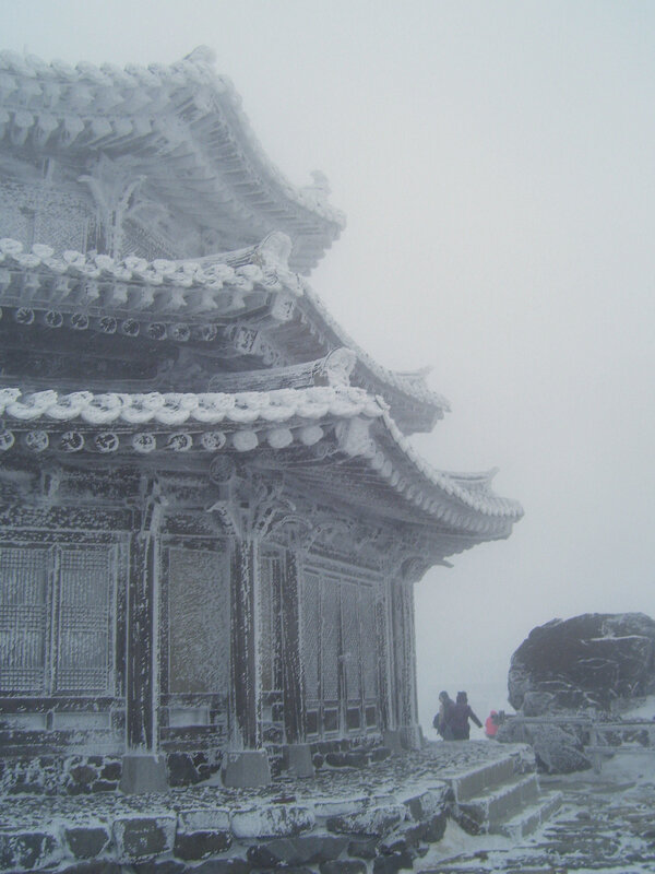 Snow-covered temple in fog