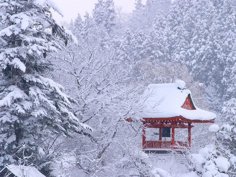 Snow-covered temple in winter forest