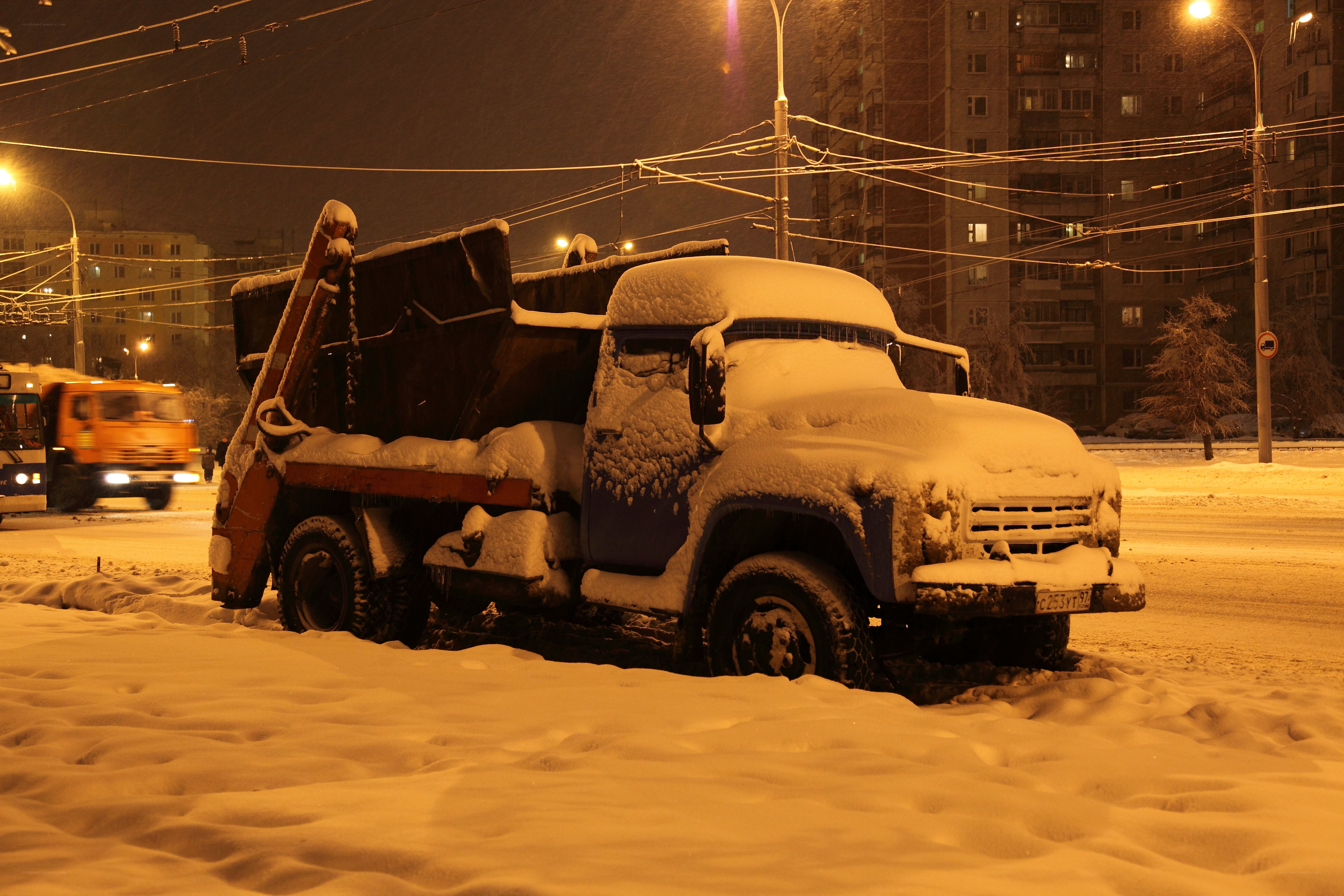 Snow-covered truck at night