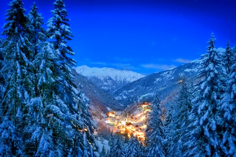 Snow-covered Village — Blue, Serene, Night, Photograph, Mountains, Trees, Lights