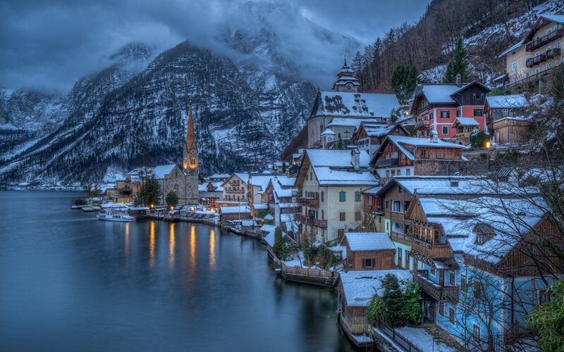 Snow-covered Village by Lake — Blue, Serene, Winter, Photograph, Mountains, Church, Houses