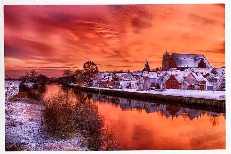 Snow-covered Village by River