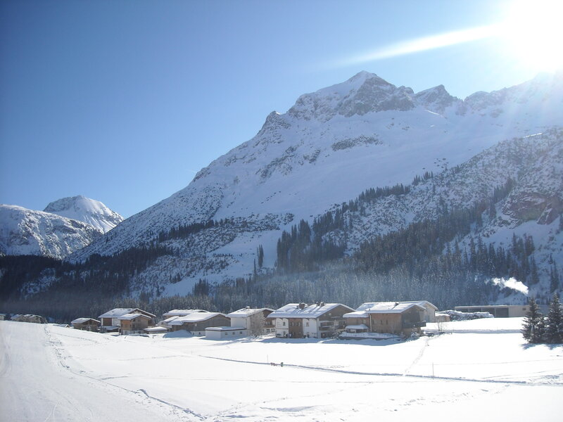 Snow-covered Village — White, Serene, Winter, Photograph, Mountains, Trees, Buildings, Blue, Brown