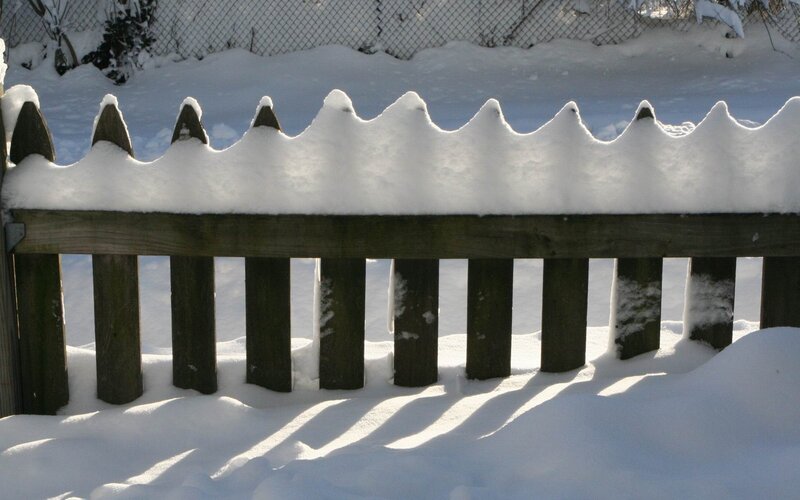 snow-covered wooden fence