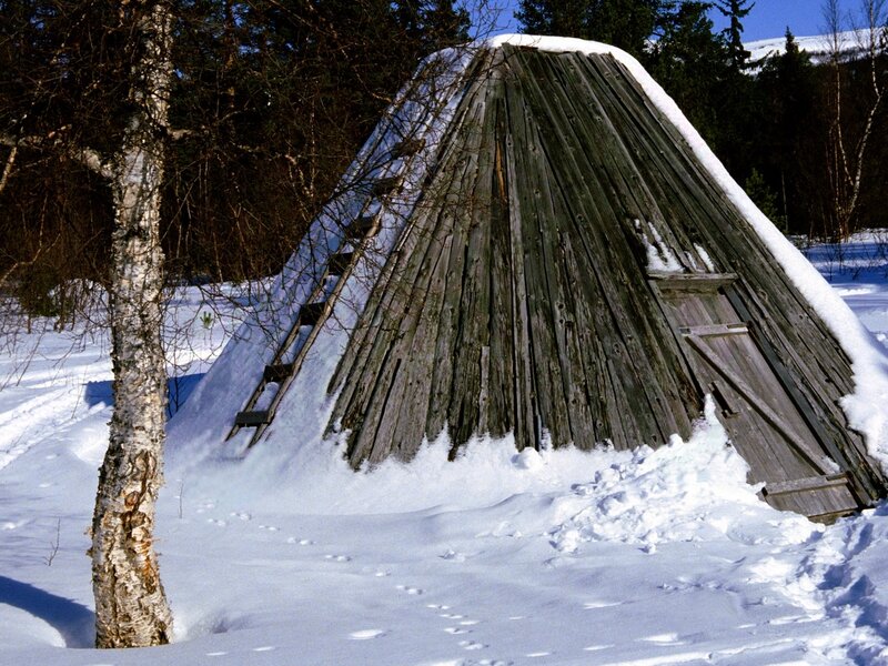 Snow-covered wooden hut in winter