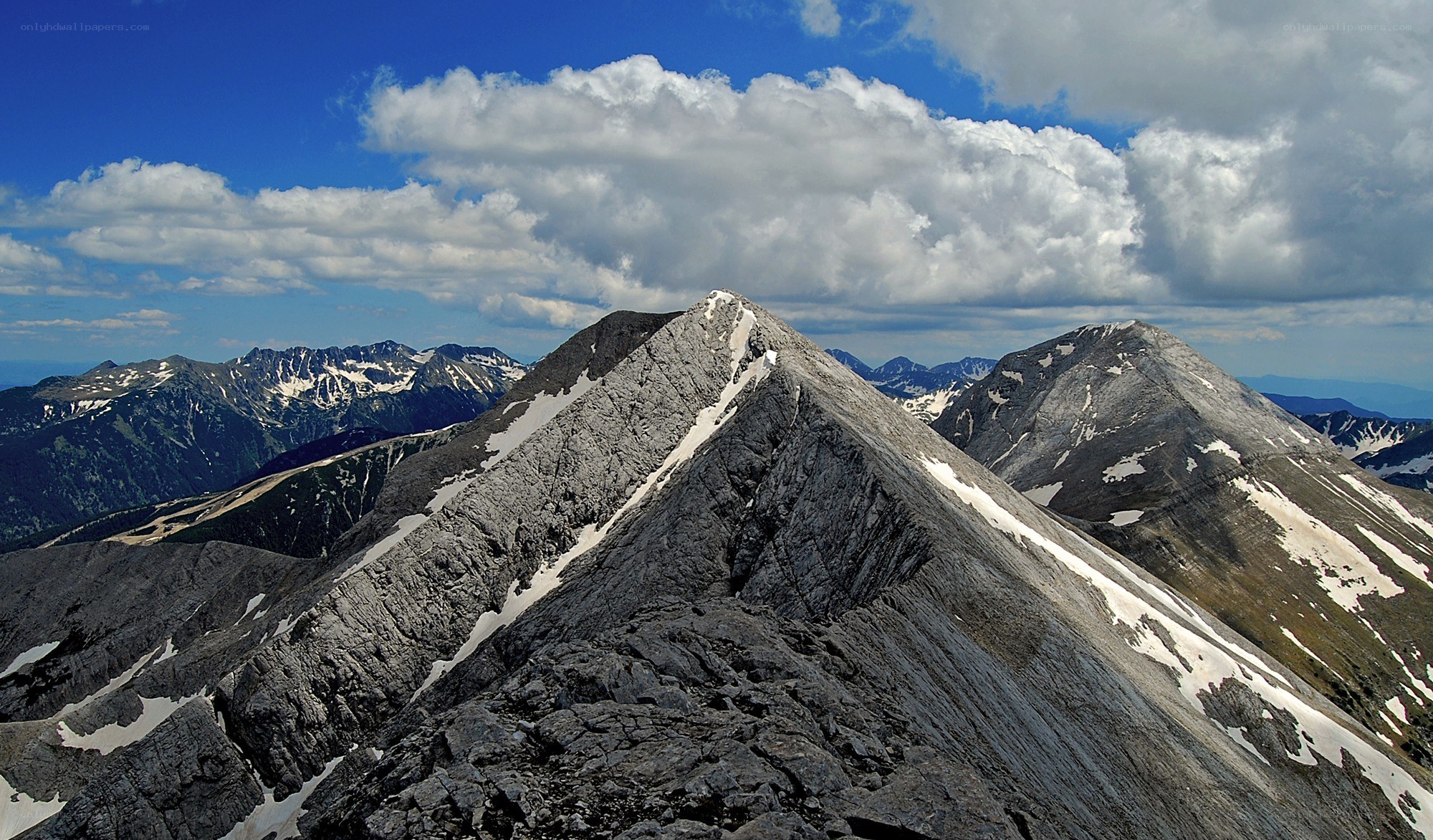 Snow-dusted mountain peaks under blue sky