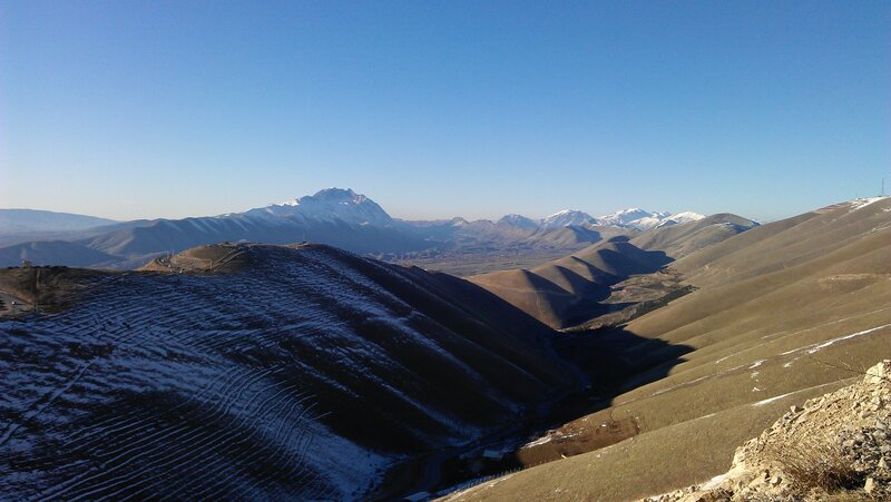 Snow-dusted mountains under clear sky