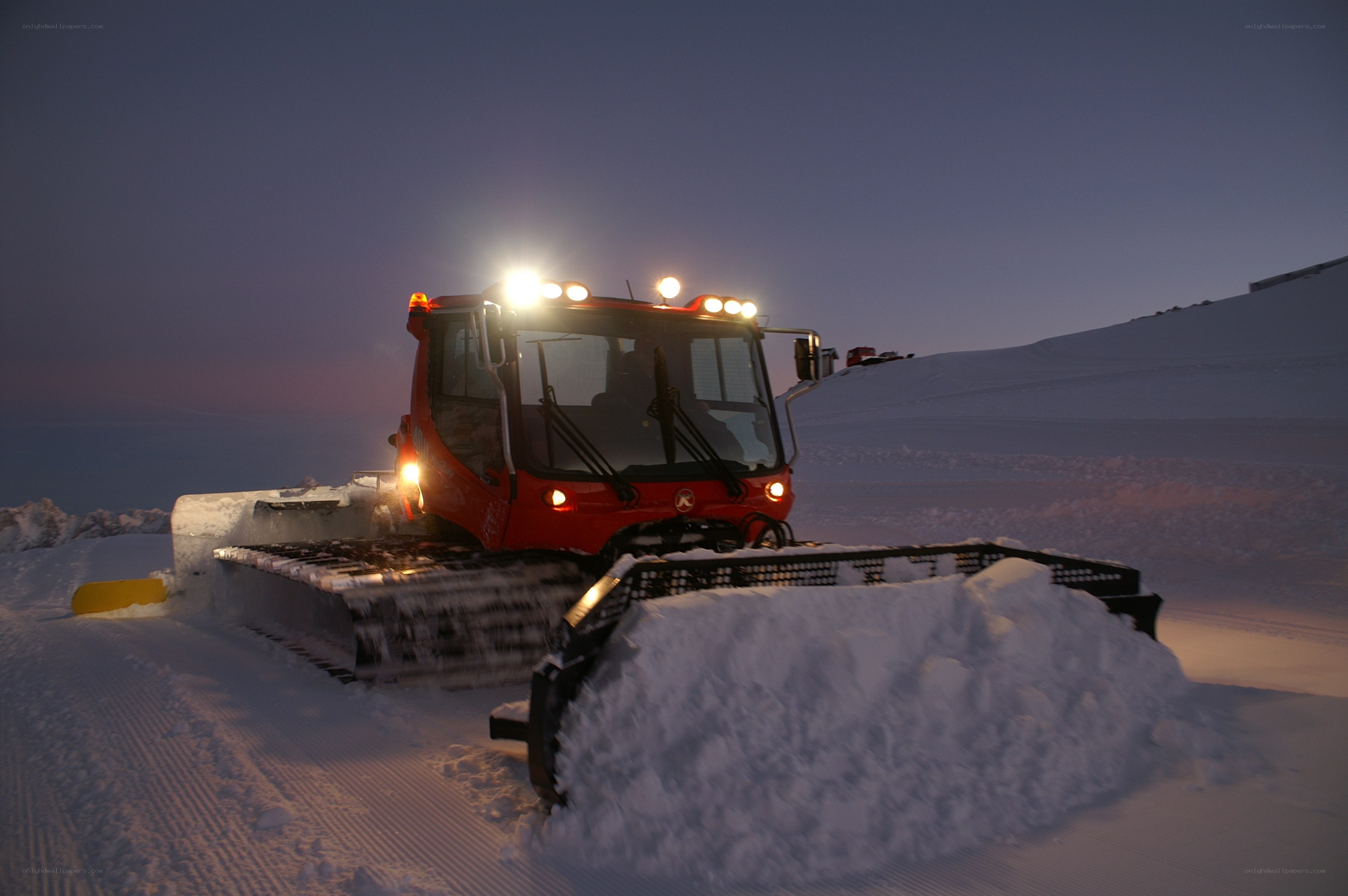 Snow groomer at dusk