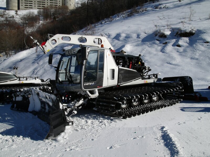 Snow groomer on a snowy slope