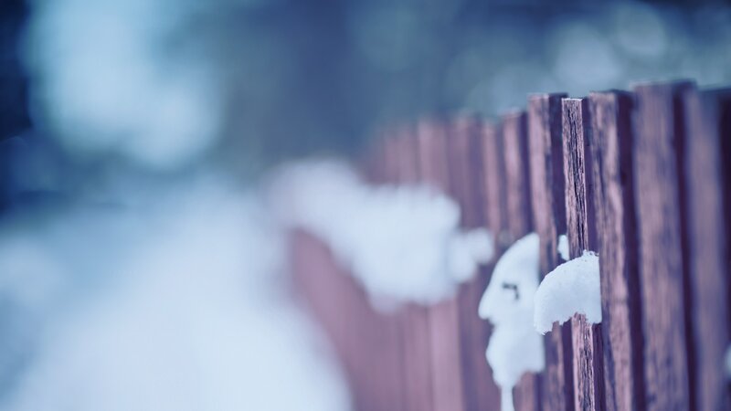 snow on a wooden fence