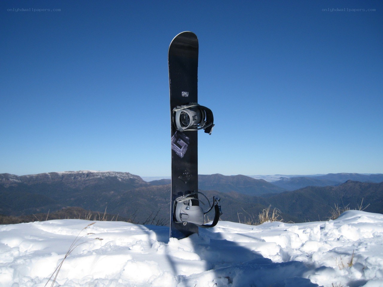 Snowboard on snowy mountain peak