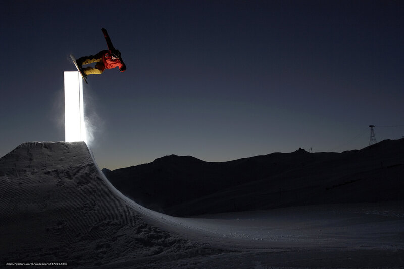 Snowboarder at night on ramp