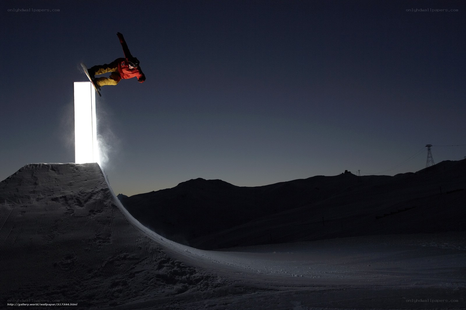Snowboarder at night on ramp