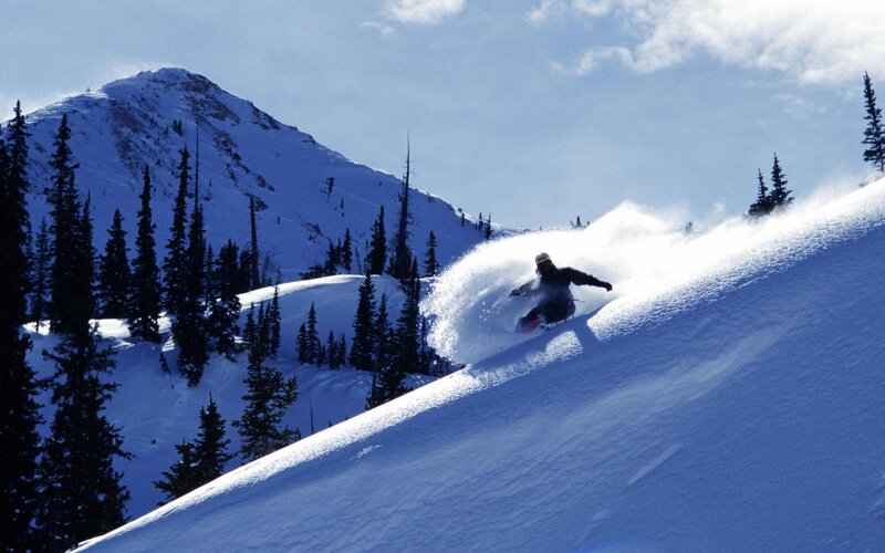 Snowboarder carving down a mountain