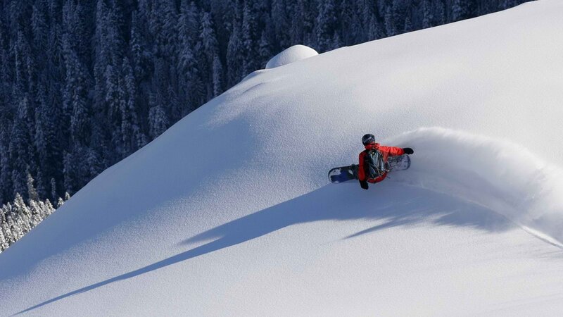 Snowboarder carving down a slope