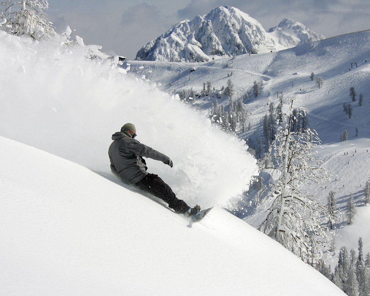Snowboarder carving down mountain
