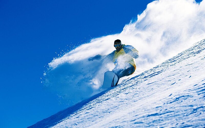 Snowboarder carving down slope