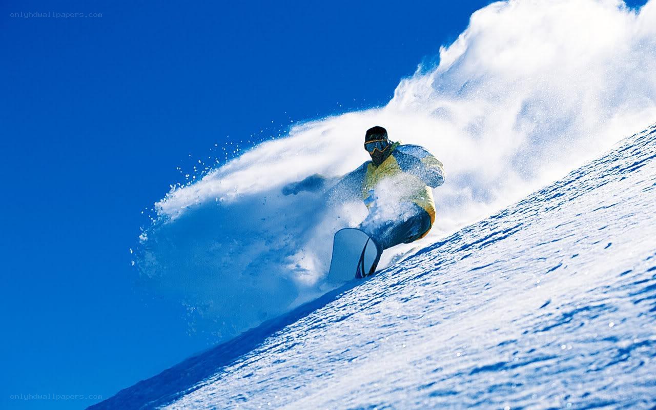 Snowboarder carving down slope