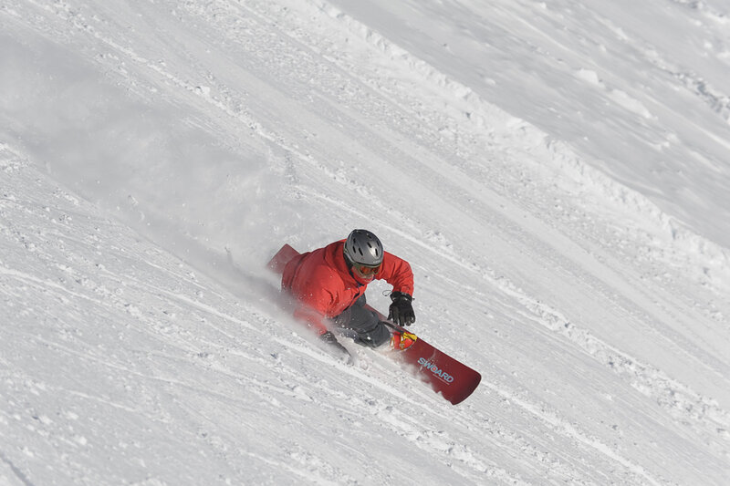 Snowboarder carving down slope