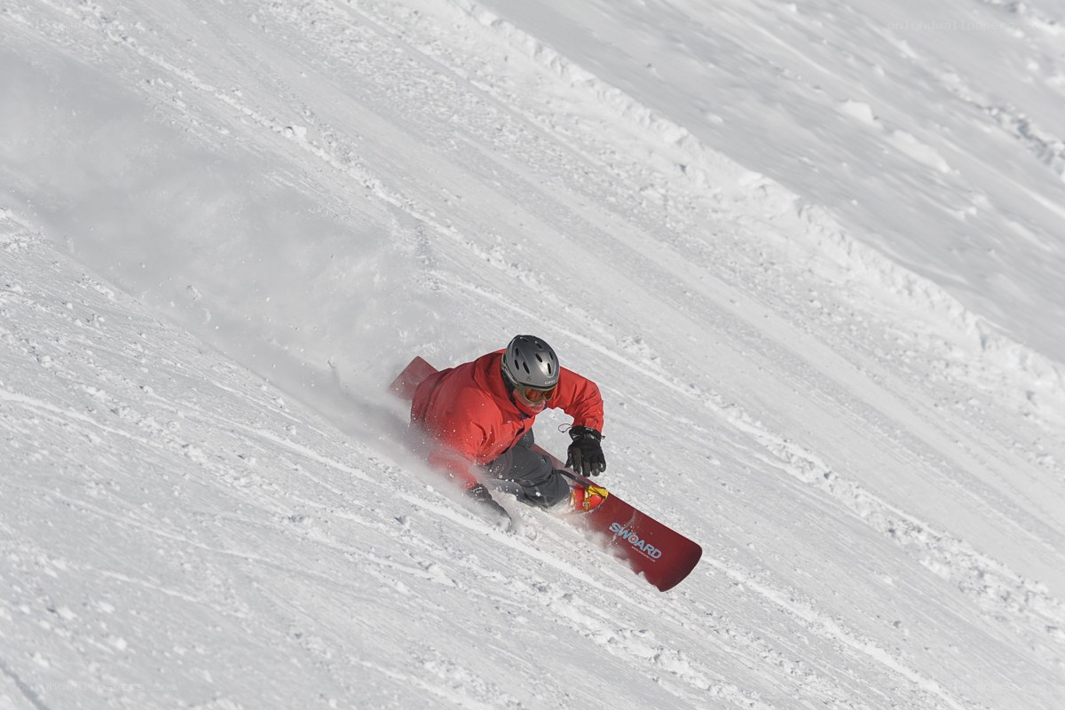 Snowboarder carving down slope