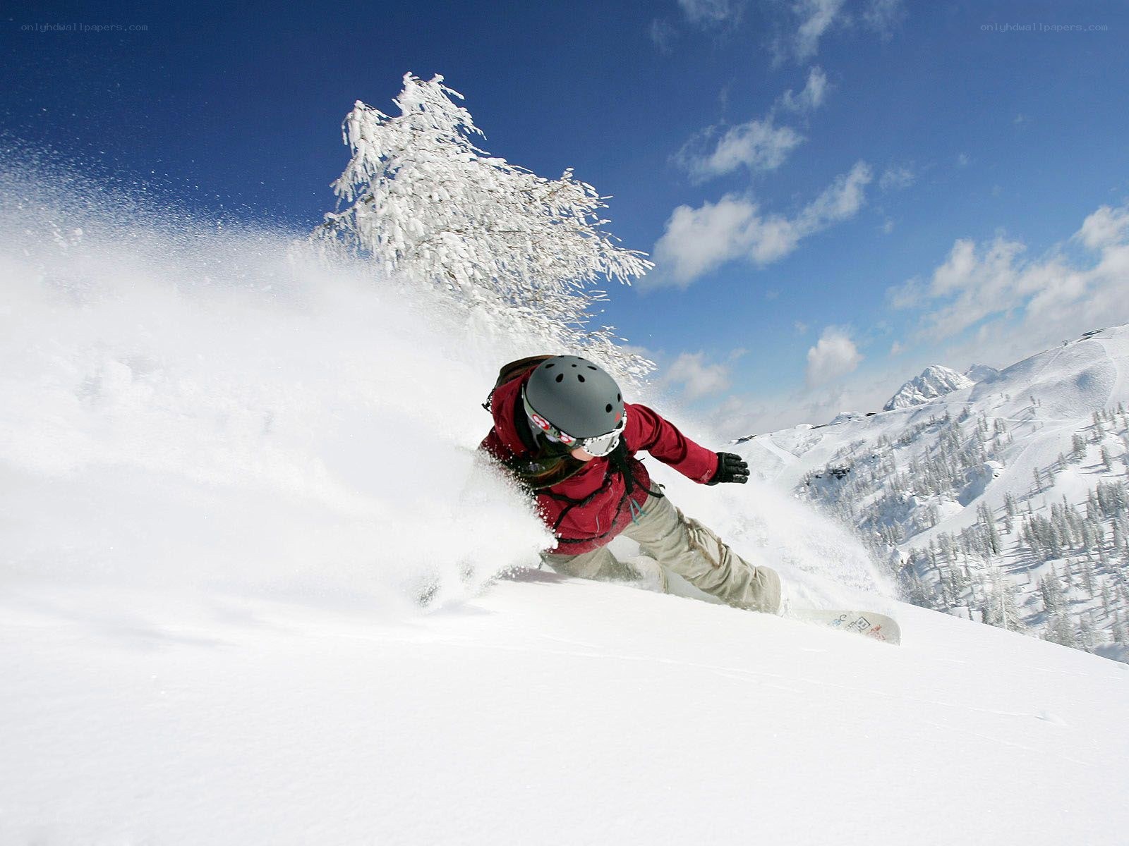 Snowboarder carving down slope