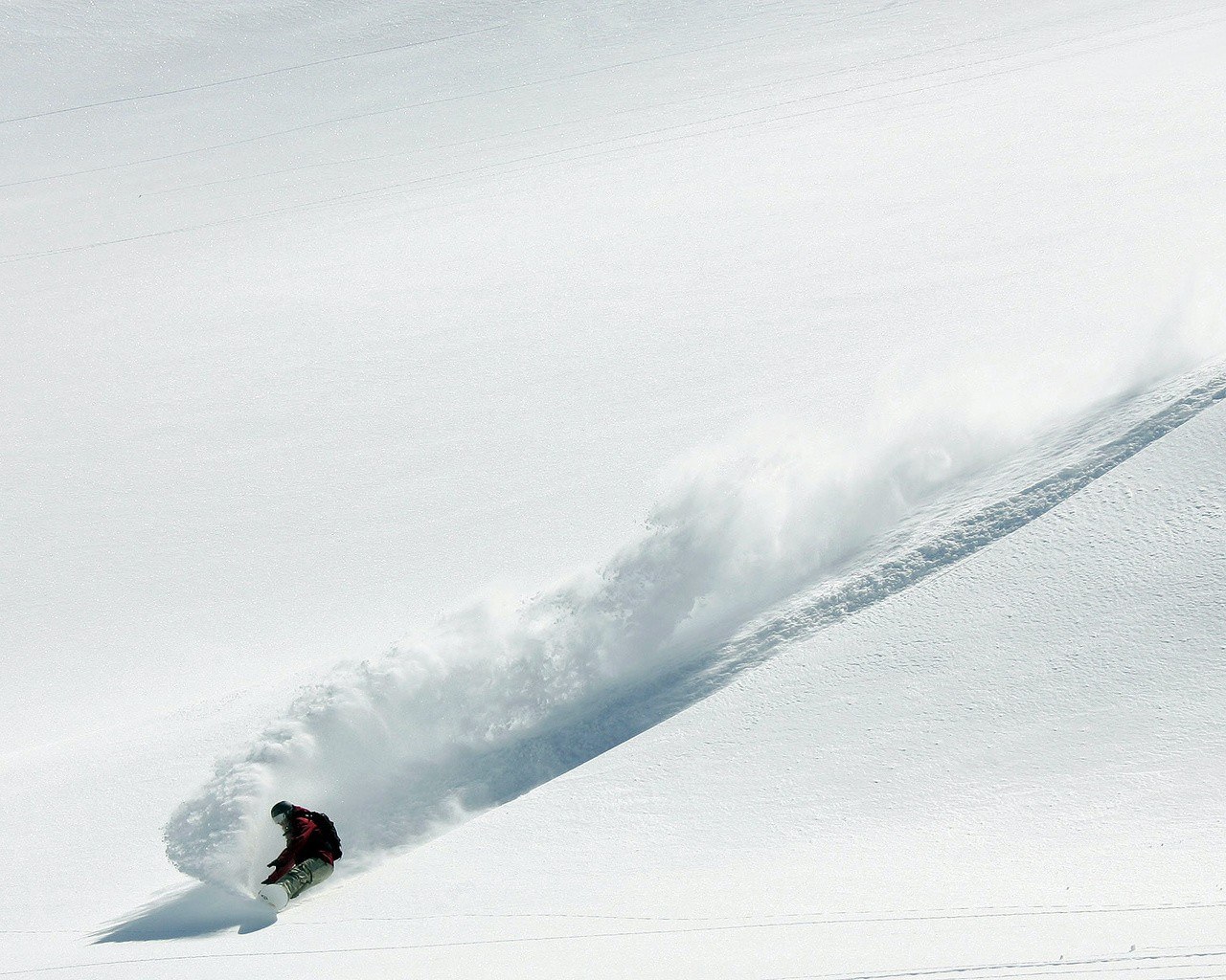 Snowboarder carving down slope