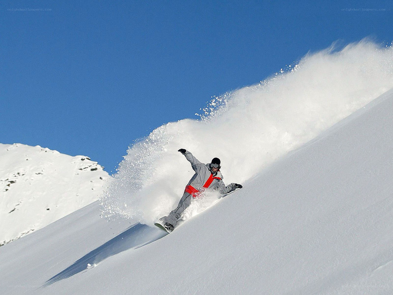 Snowboarder carving down slope