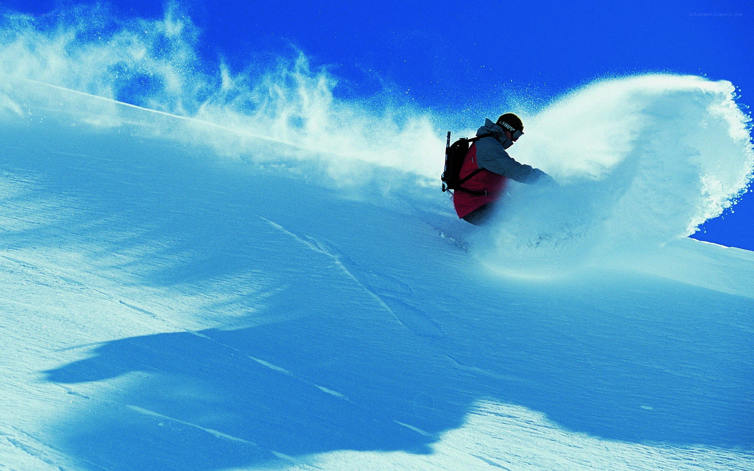 Snowboarder carving down slope