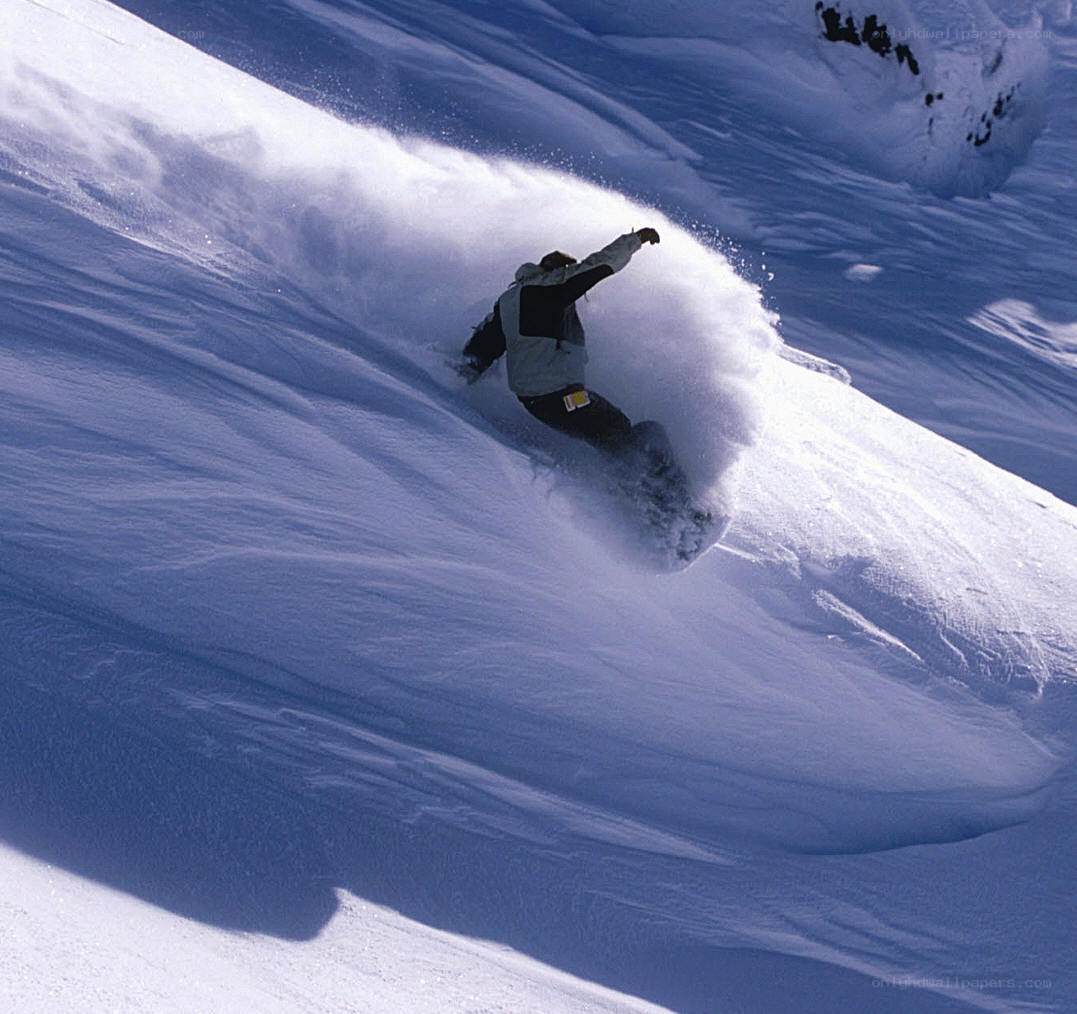 Snowboarder carving down slope