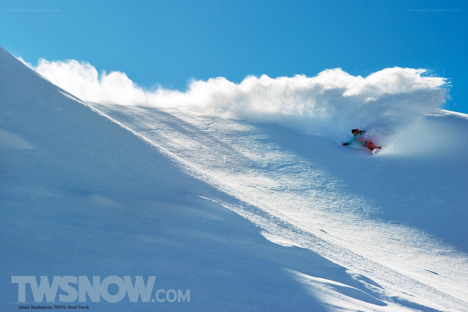 Snowboarder carving down slope
