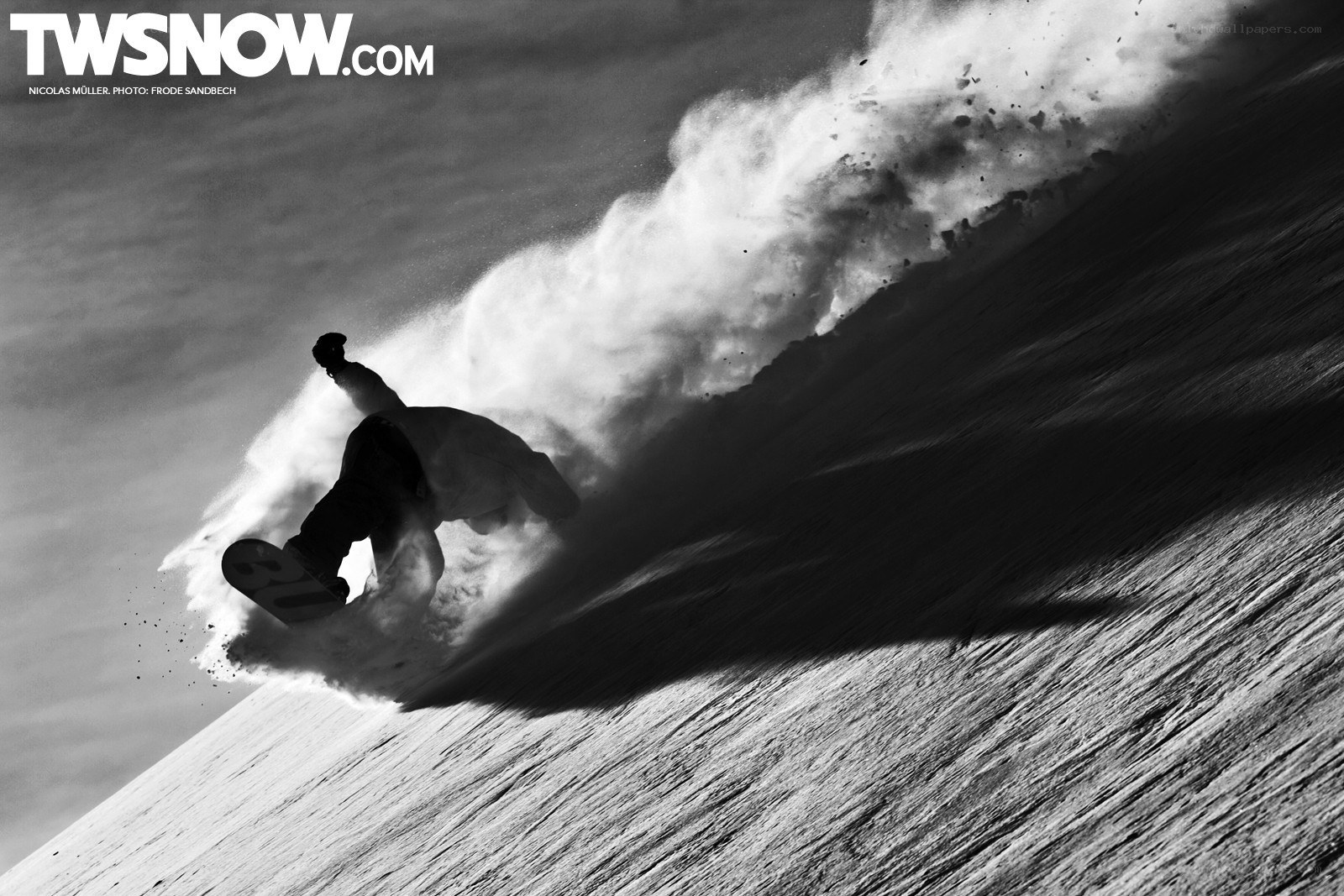 Snowboarder carving down slope