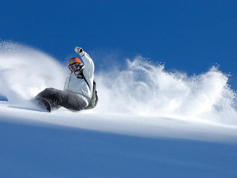 Snowboarder carving down slope