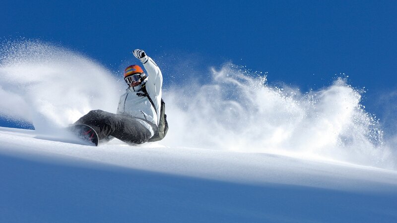 Snowboarder carving on a sunny day