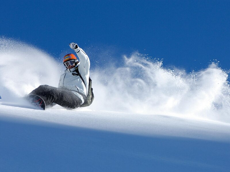 Snowboarder carving on a sunny day