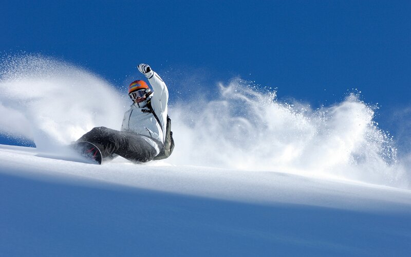 Snowboarder carving on a sunny day