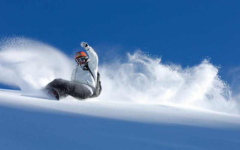 Snowboarder carving on a sunny day